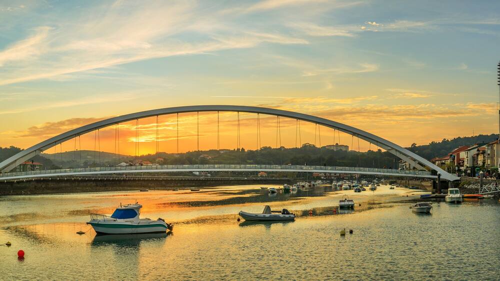 Une rivière avec des bateaux, un pont et des bâtiments le long de la rive.