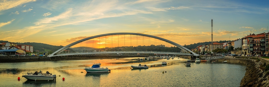 Un río con barcos, un puente y edificios a lo largo de la orilla.