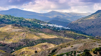 A mountainous landscape with a village nestled among rolling hills.