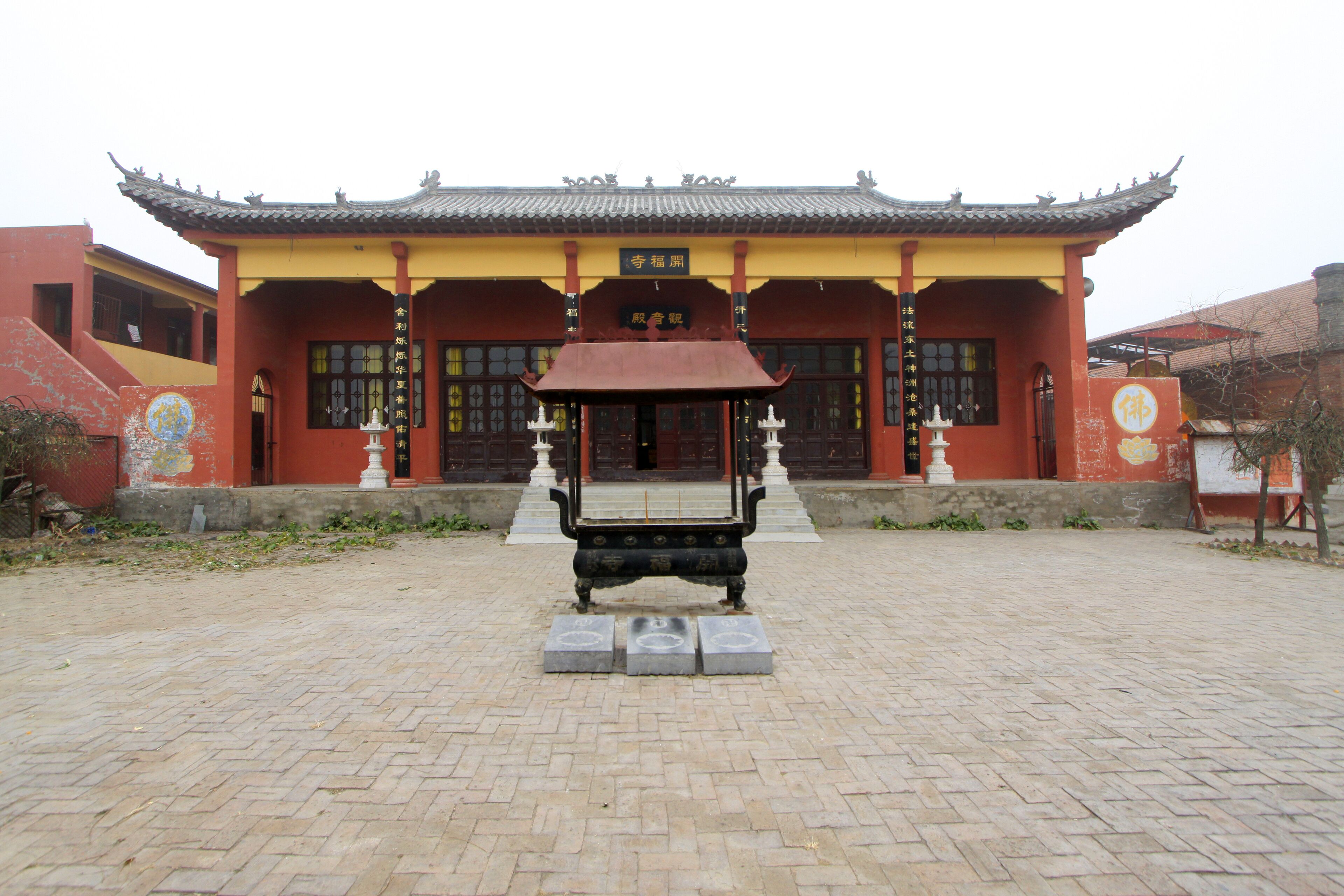 A traditional Chinese building with a tiled roof and a large courtyard.