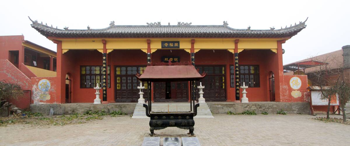 A traditional Chinese building with a tiled roof and a large courtyard.