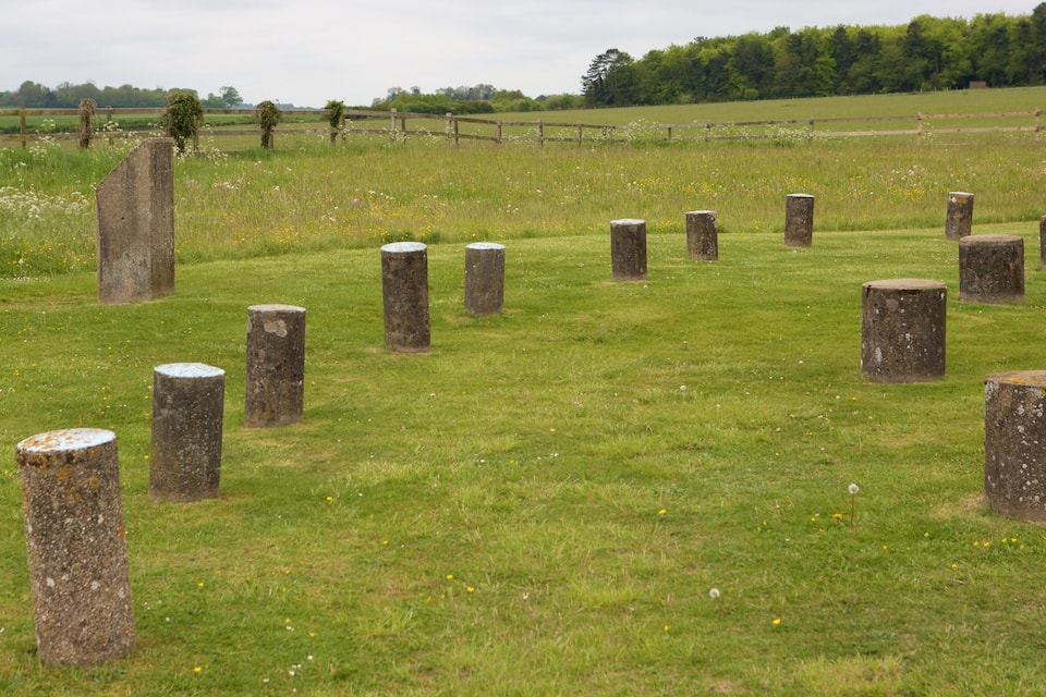A field with stone posts and a wooden fence.
