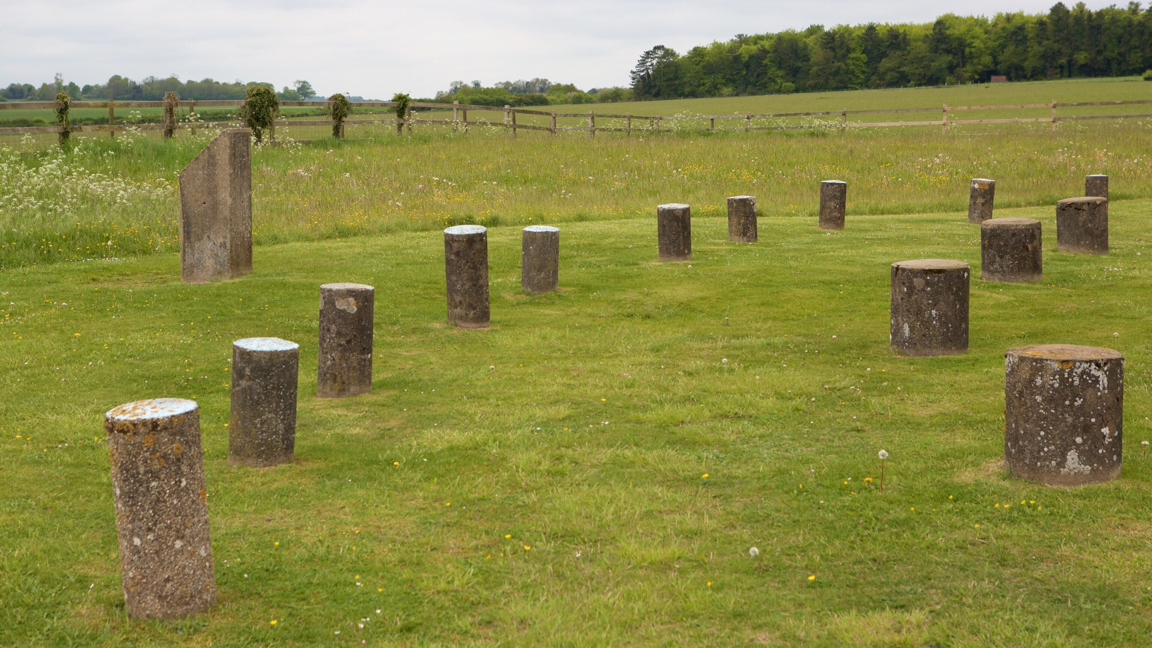 A field with stone posts and a wooden fence.