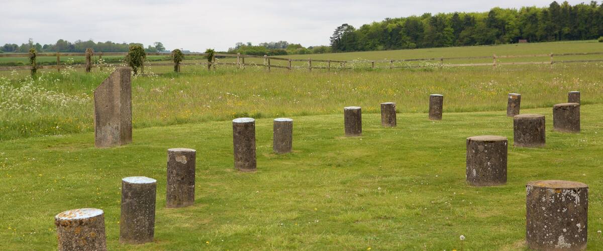 A field with stone posts and a wooden fence.