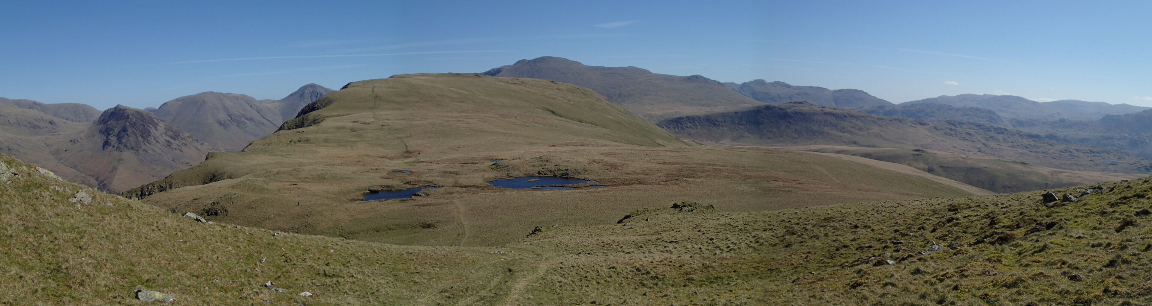 A mountainous landscape with a prominent hill and two small ponds.
