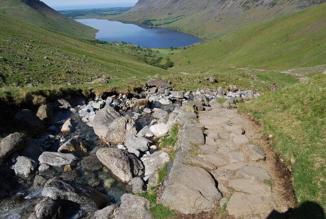 A rocky stream with a lake in the background.