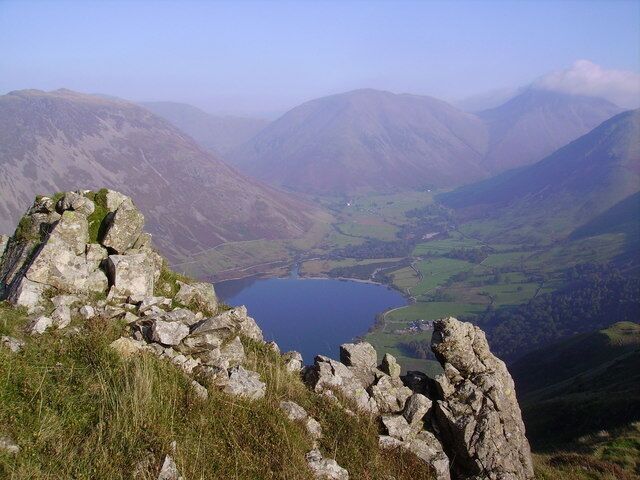 A mountainous landscape with a lake and rocky outcrops.