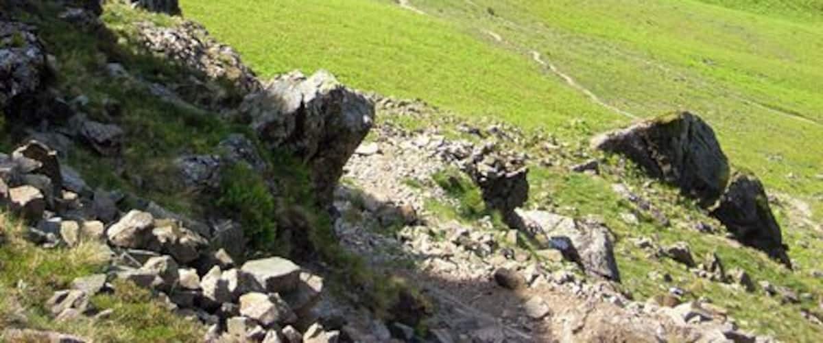 Path descending from Yewbarrow to Wast Water The view from Dropping Crag. The path can be seen traversing the hillside to rejoin the ridge. Over Beck is in the valley to the right. Bowderdale Farm is to the extreme right