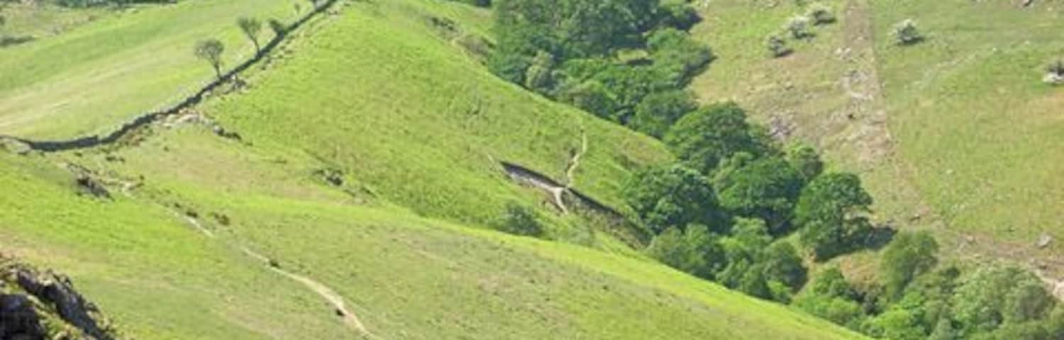 Path descending from Yewbarrow to Wast Water The view from Dropping Crag. The path can be seen traversing the hillside to rejoin the ridge. Over Beck is in the valley to the right. Bowderdale Farm is to the extreme right