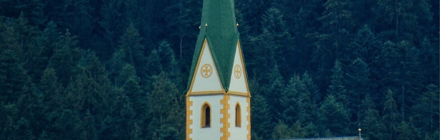 A fairytale church sits high on the hilltop overlooking the tiny village far below.
Timber houses with steeply pitched roofs, balconies with window shutters open wide. Flowering geraniums spilling from planter boxes like pink and red waterfalls cascading to the ground. Beyond dark green fir trees march like soldiers up the mountain in an attempt reach the sky. Austria you are ridiculously beautiful more than my simple words can describe.