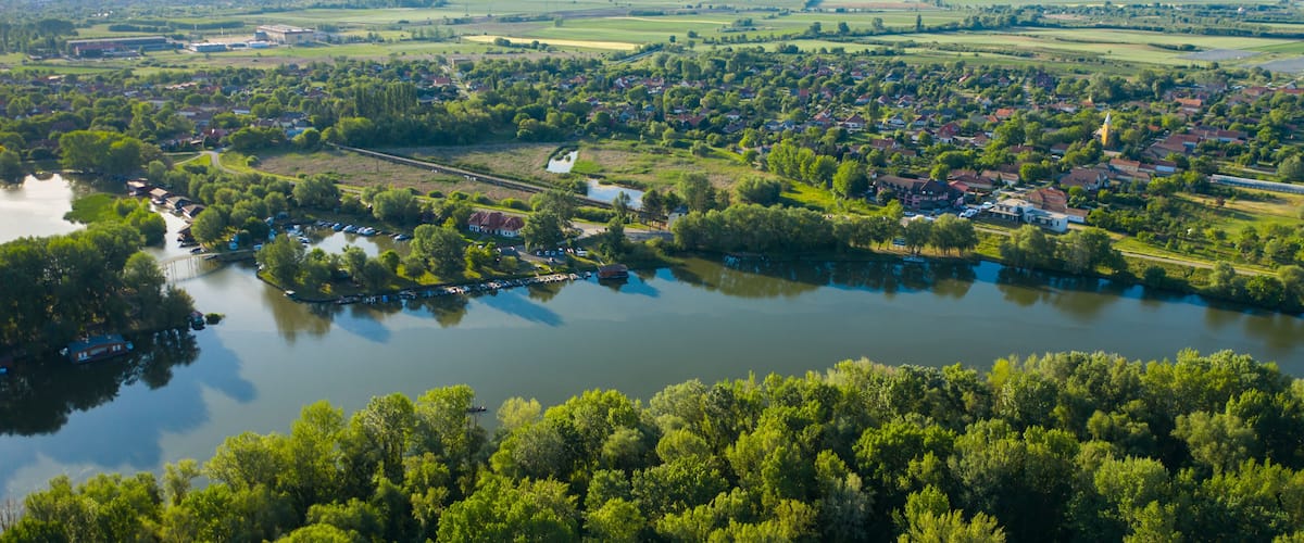A river winding through a town with houses and greenery.