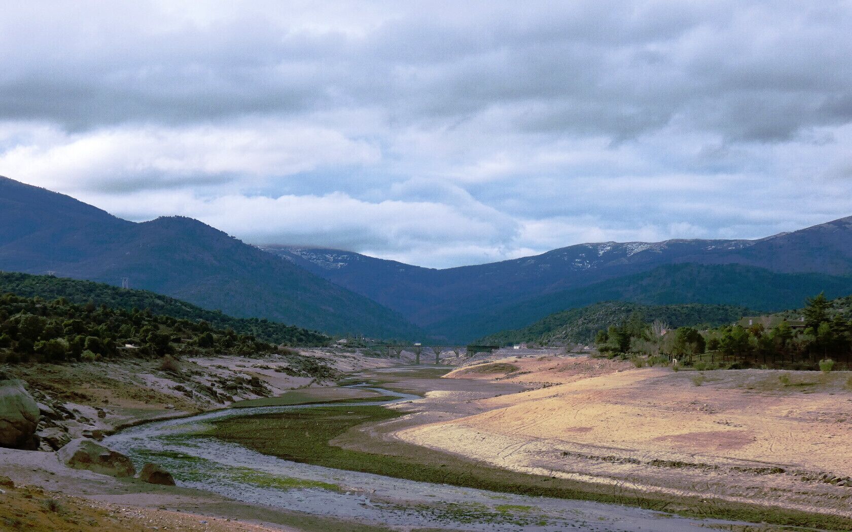 A river winding through a valley with mountains in the background.