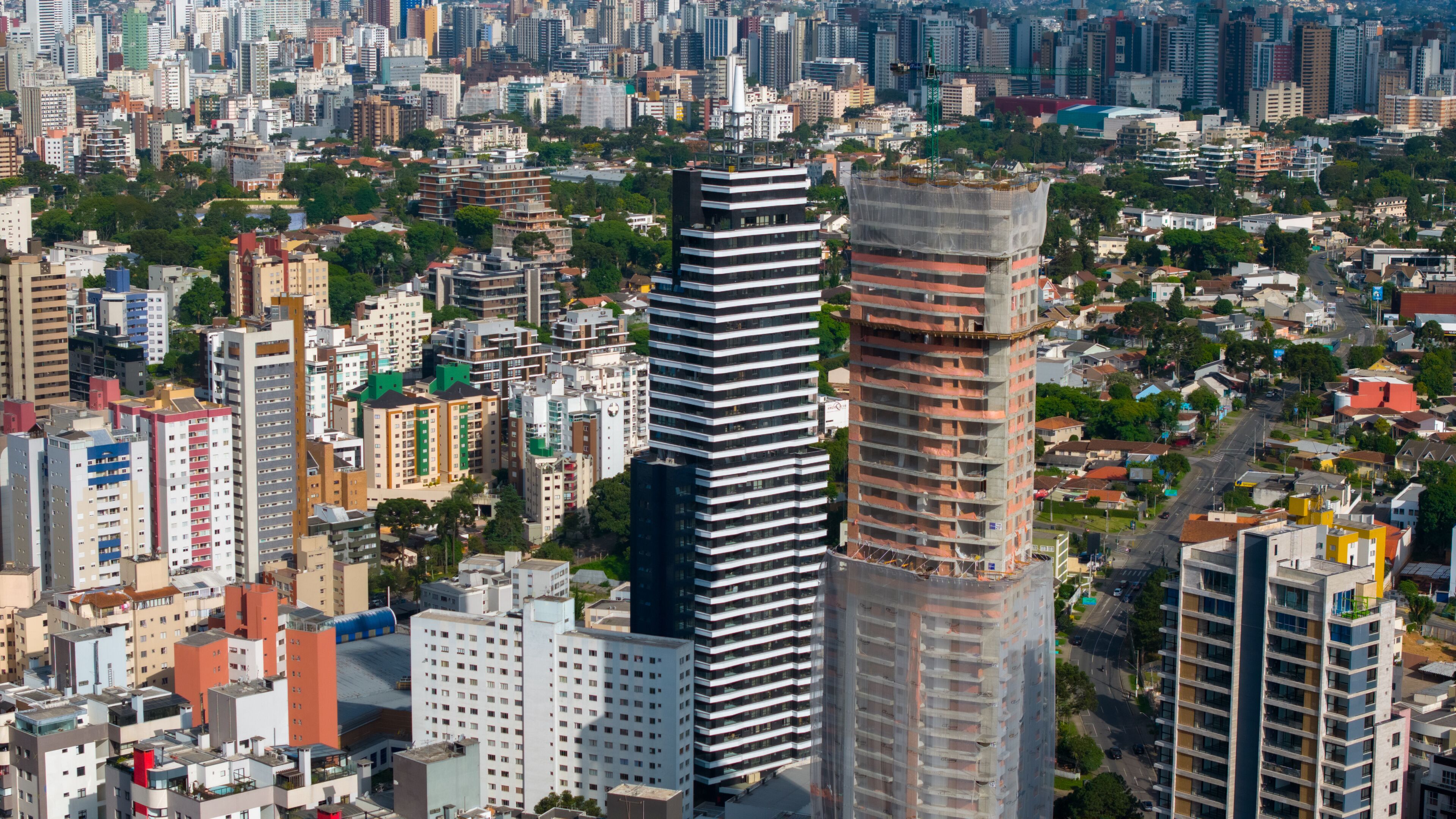 A cityscape with a prominent modern skyscraper, dense urban buildings, and a mix of residential and commercial structures.