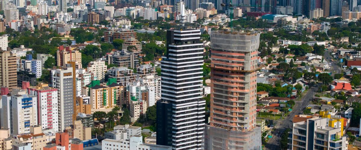 A cityscape with a prominent modern skyscraper, dense urban buildings, and a mix of residential and commercial structures.