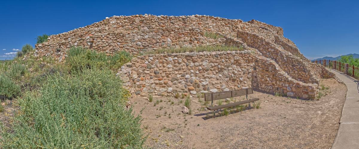 A large stone structure with a bench in front.