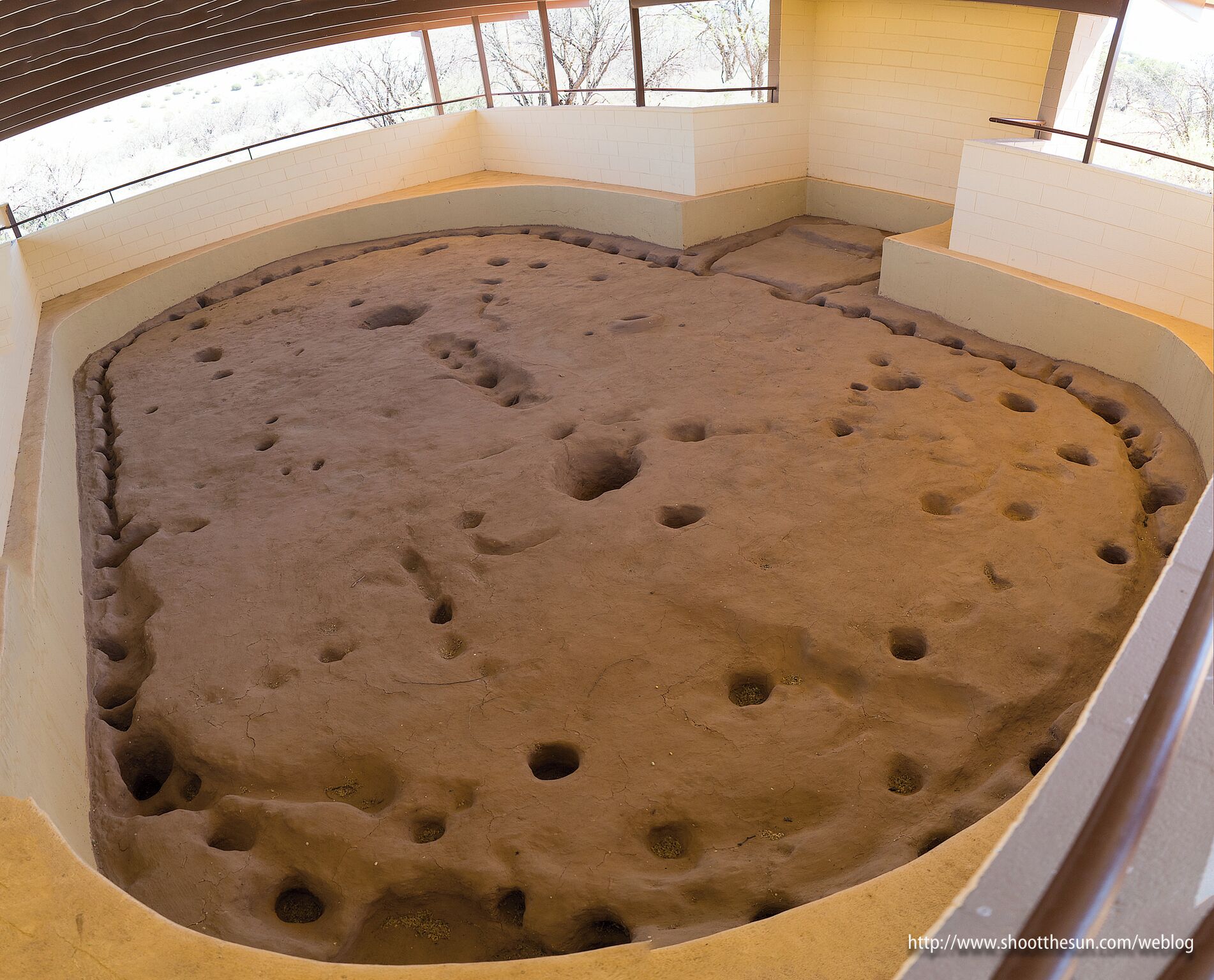 Directly outside the monument proper sits the uncovered remains of a pit dwelling originally constructed in 1850.  The dwelling would have been covered inside an oblate oval "cocoon" of mud and clay supported by beams and poles situated in the holes you see here.  It would have been a relatively comfortable dwelling in all seasons.   With a single opening for a door, the coolness of the interior would have been maintained during the hot summer.  In the winter, a fire pit directly under the only opening in the roof would have provided enough heat (with the door closed off by leather or cloth) to keep the inhabitants warm and dry.