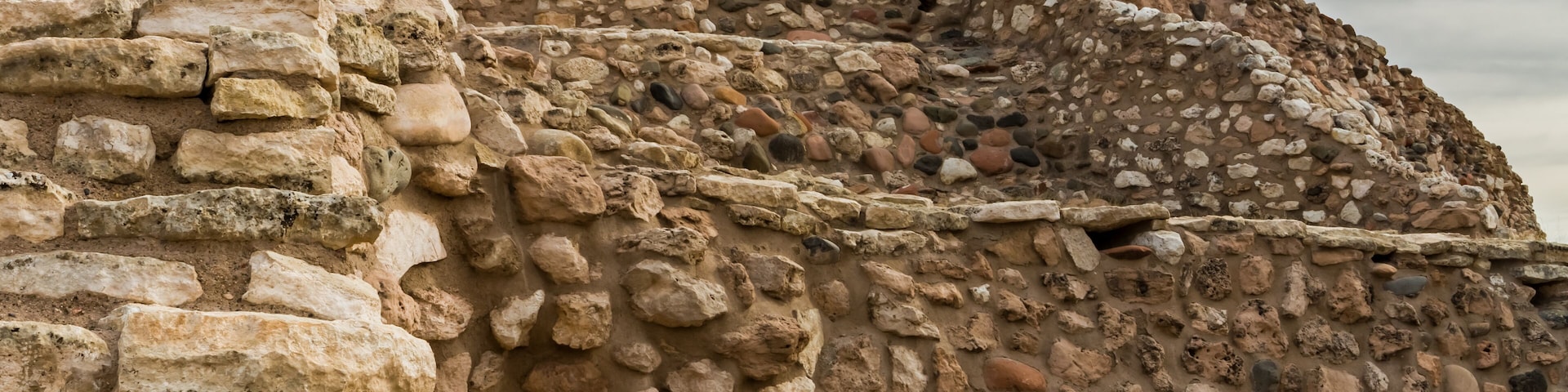 Antiguas ruinas de piedra con muros irregulares y piedras dispersas.