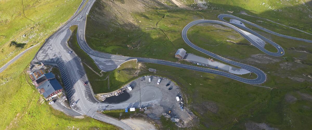 An aerial view of a complex road interchange surrounded by green hills.