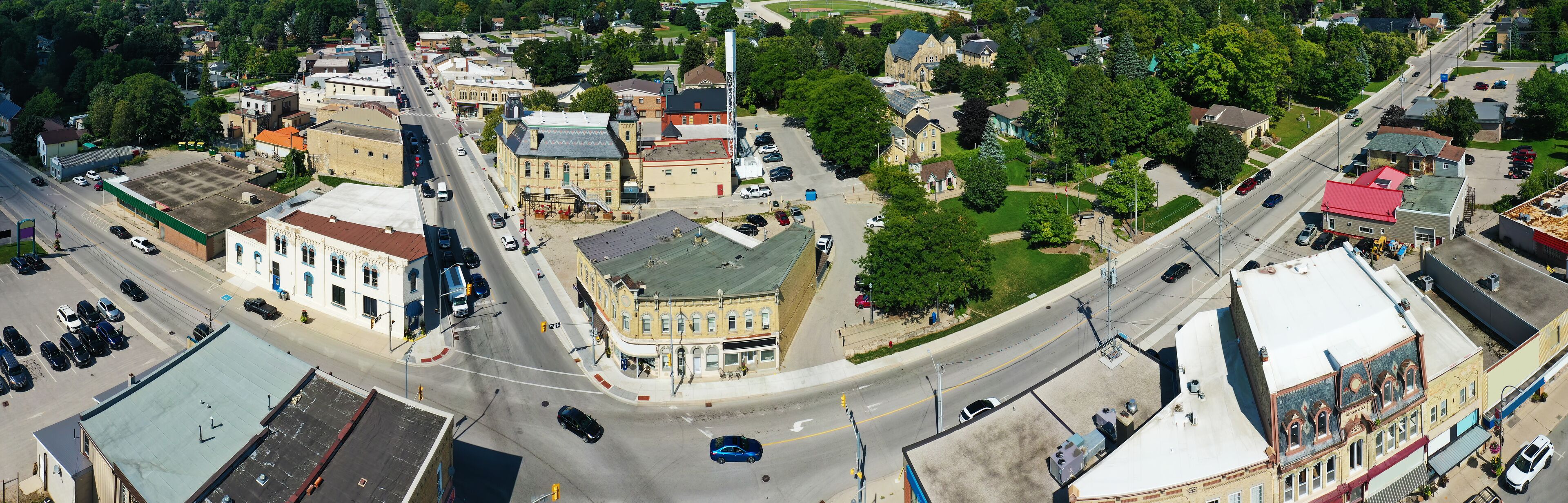 An aerial view of a town with a central street, historic buildings, and a baseball field.