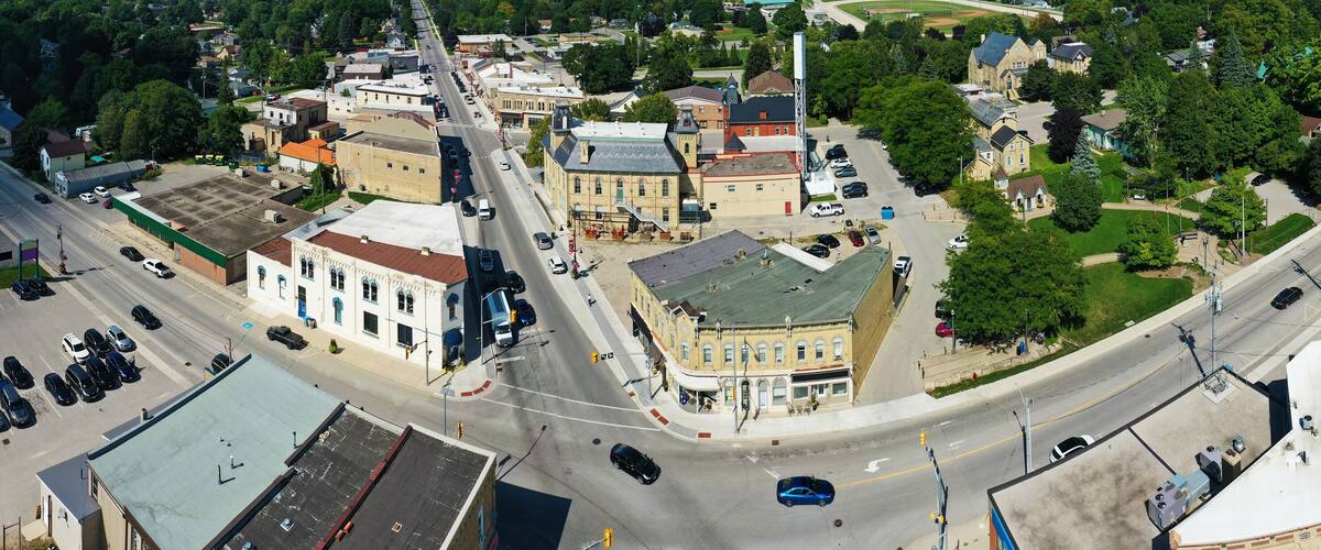 An aerial view of a town with a central street, historic buildings, and a baseball field.