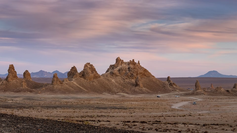 A desert landscape with prominent rock formations and a winding road.