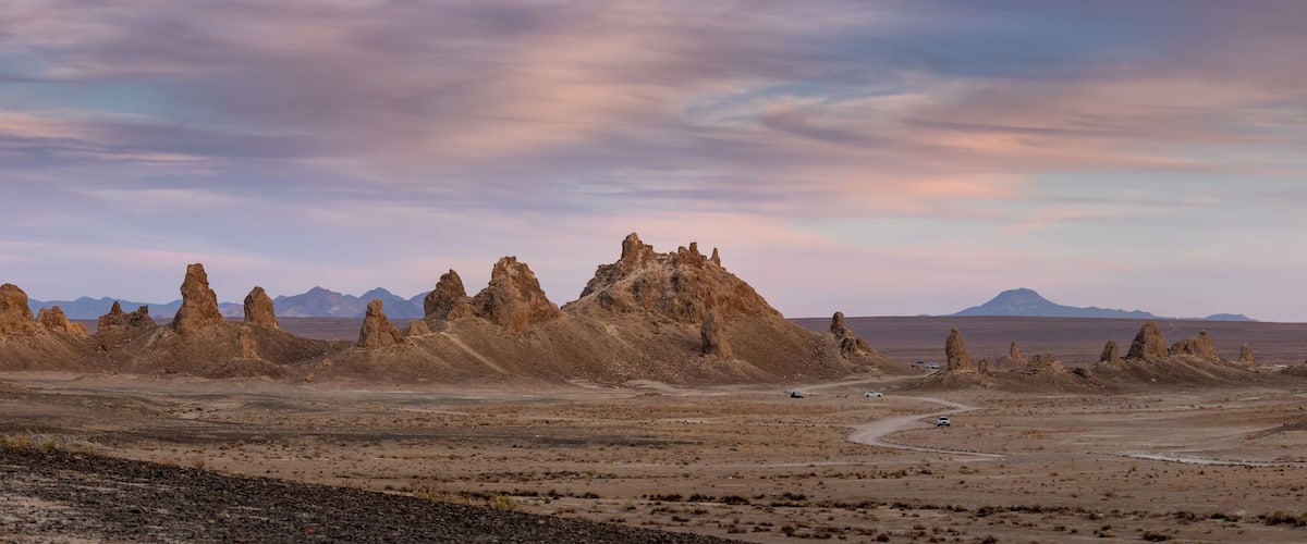 A desert landscape with prominent rock formations and a winding road.