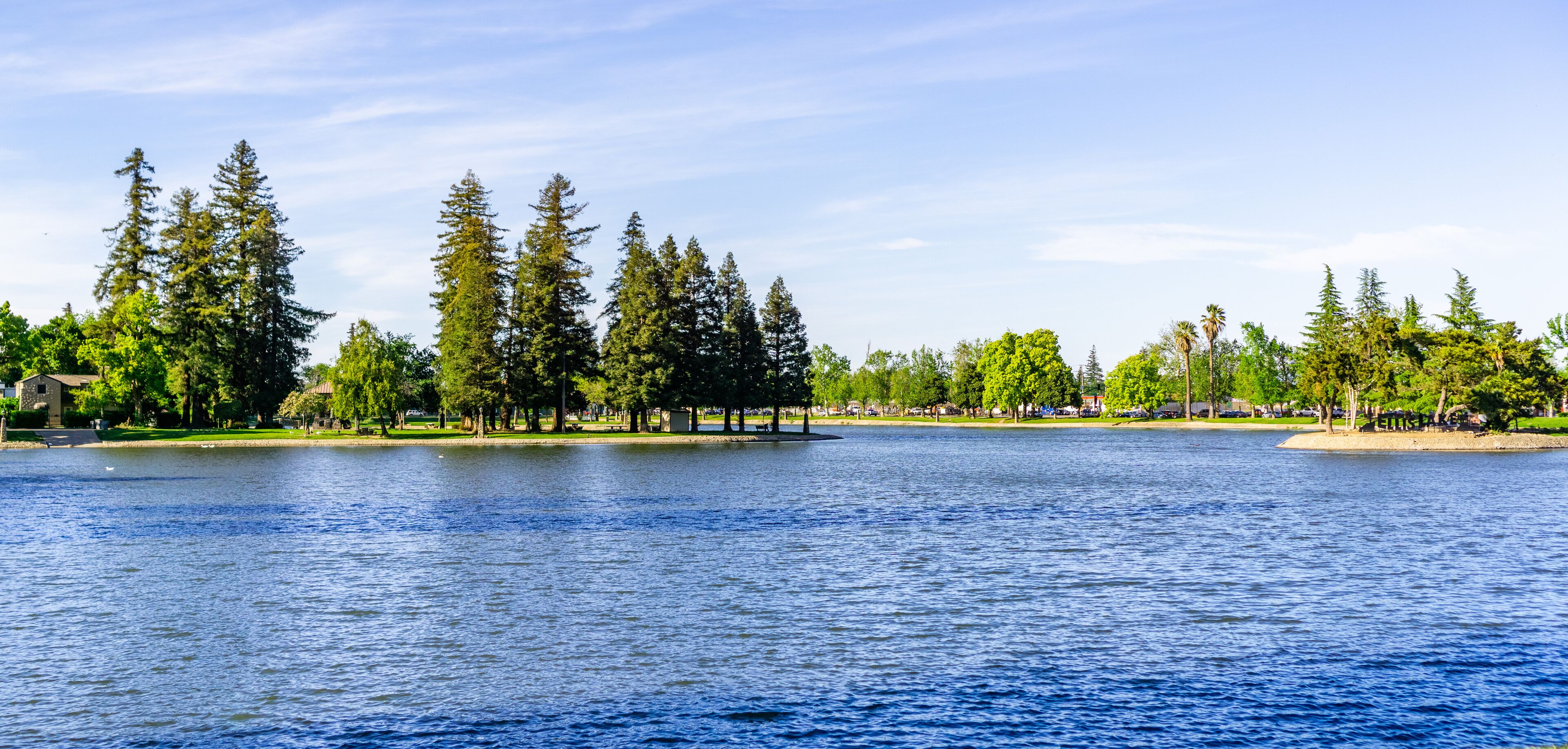 A lake with trees and a gazebo.