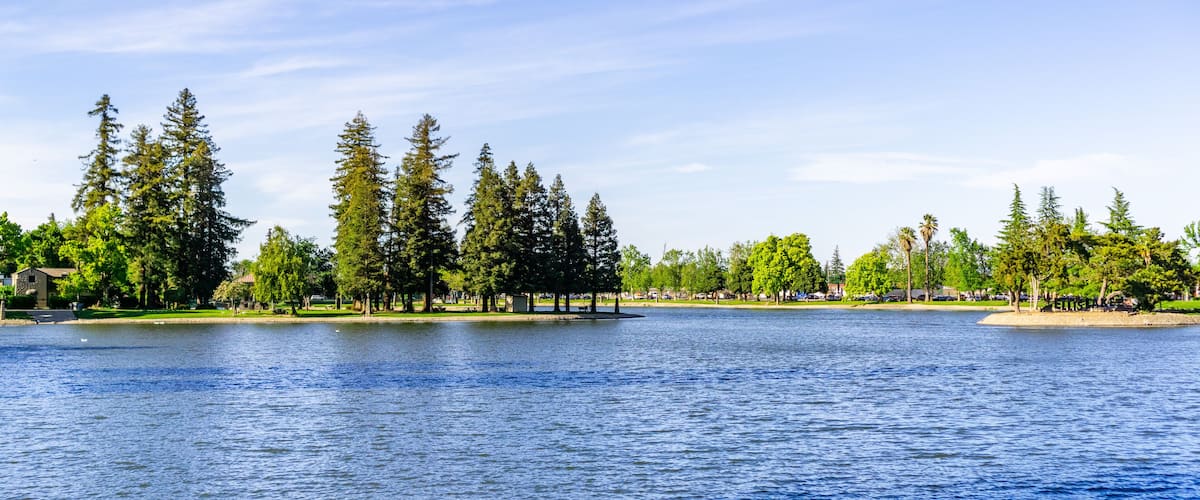 A lake with trees and a gazebo.