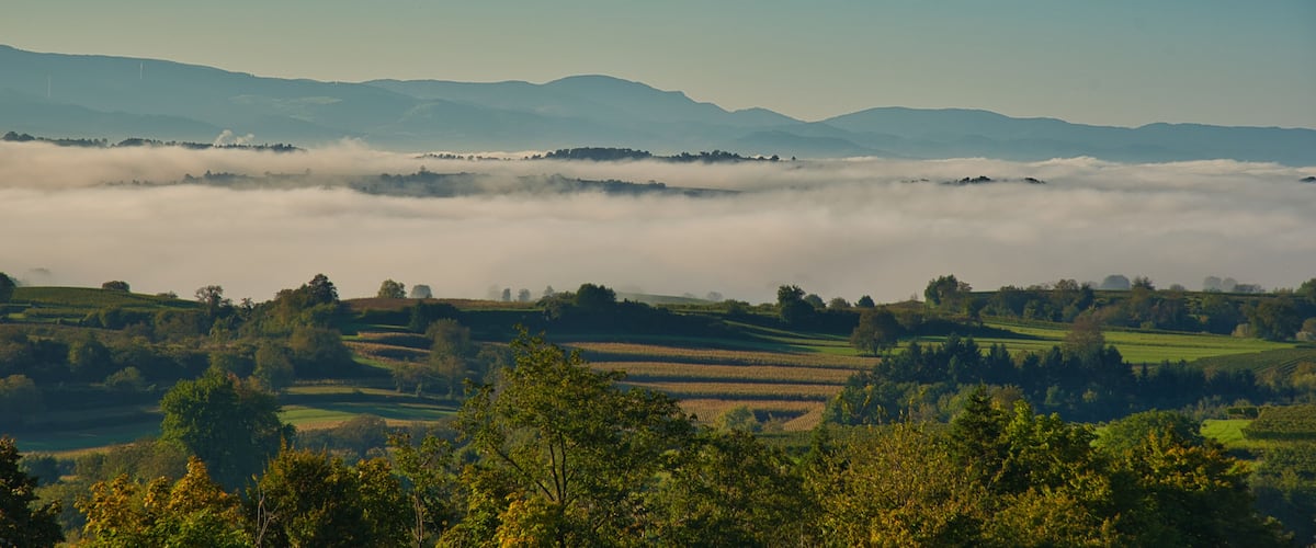 Rolling hills, a valley, and a distant mountain range.