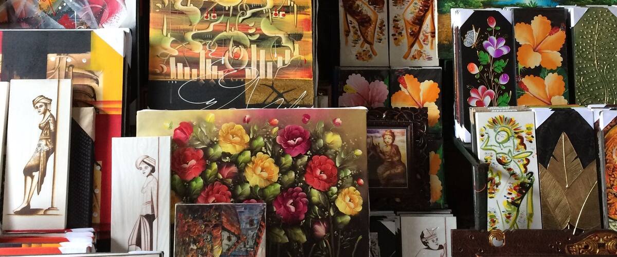 A collection of framed artworks including tropical landscapes, floral paintings, and abstract designs.