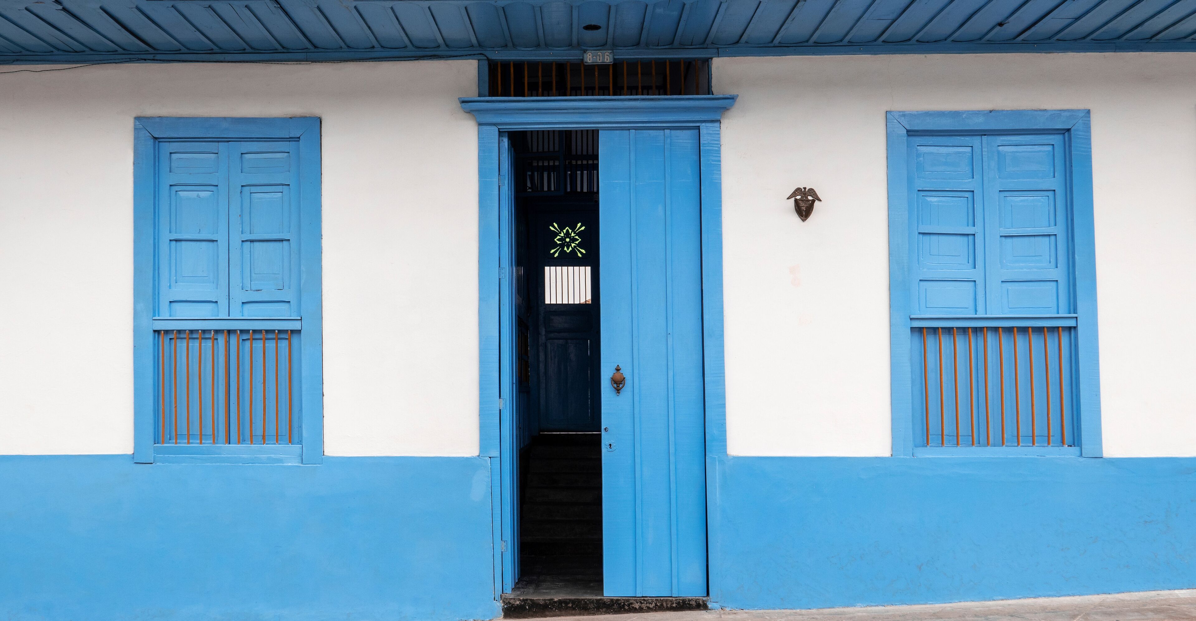 House with hallway and two windows and a door in blue and orange in Filandia Quindío, Colombia