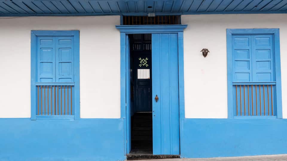House with hallway and two windows and a door in blue and orange in Filandia Quindío, Colombia