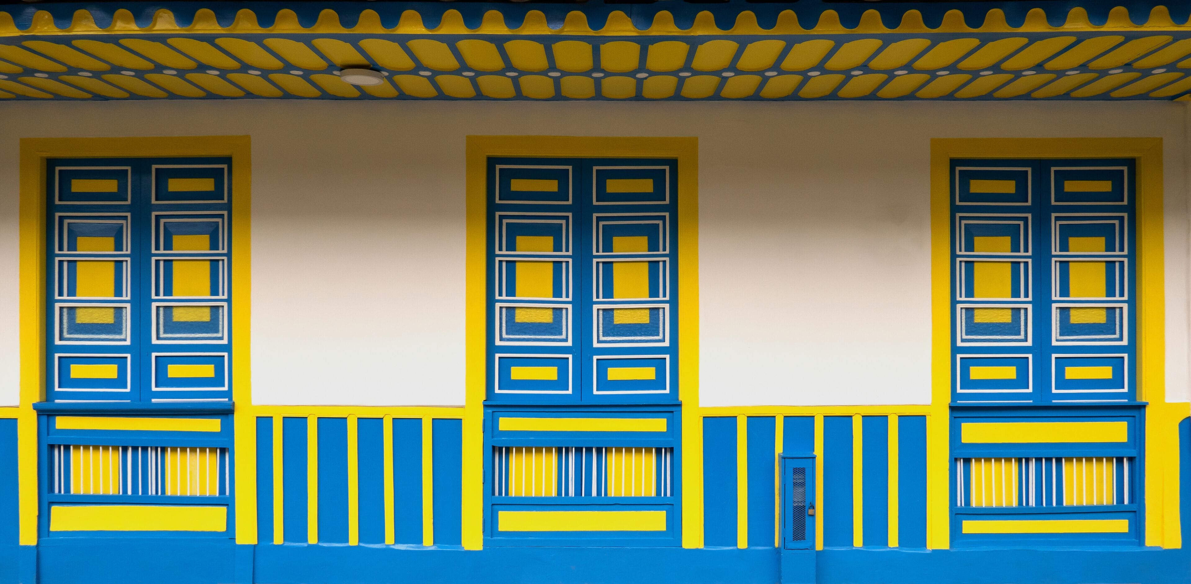 Traditional architecture of the coffee region, with three windows and base in blue and yellow colors, in Filandia Colombia,