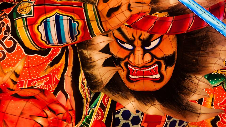 A colorful traditional mask with intricate patterns and a fierce expression.