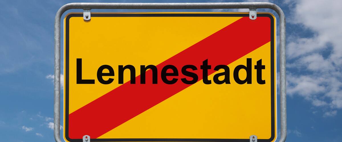 A road sign with the word "Lennestadt" against a blue sky with clouds.