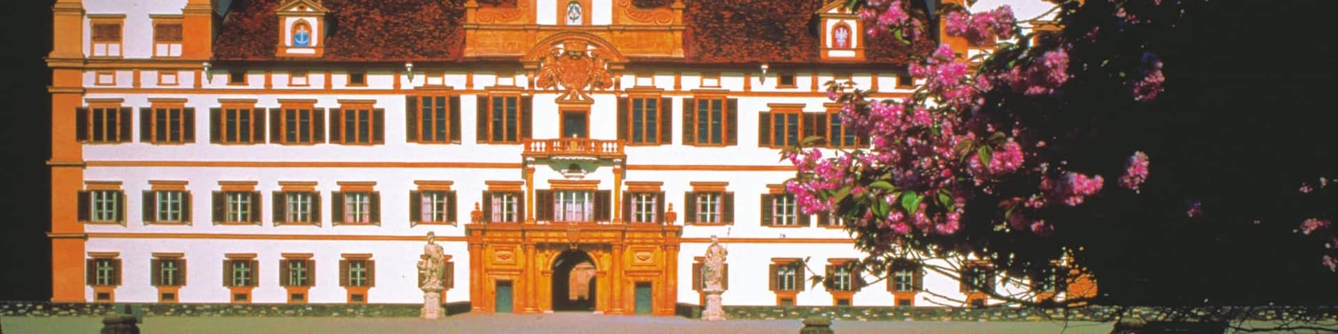 Eggenberg Palace which includes a square or plaza, flowers and chateau or palace