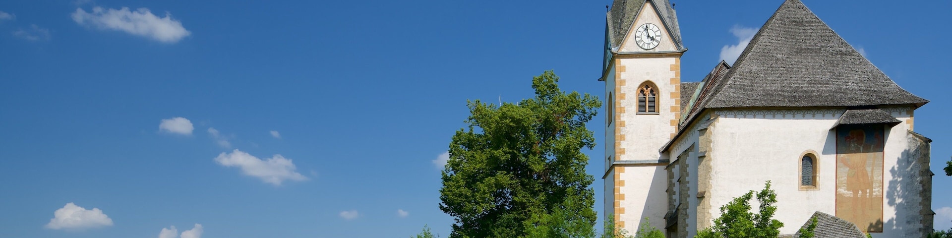 Pfarrkirche St. Primus und Felician caracterizando elementos de patrimônio e um lago ou charco