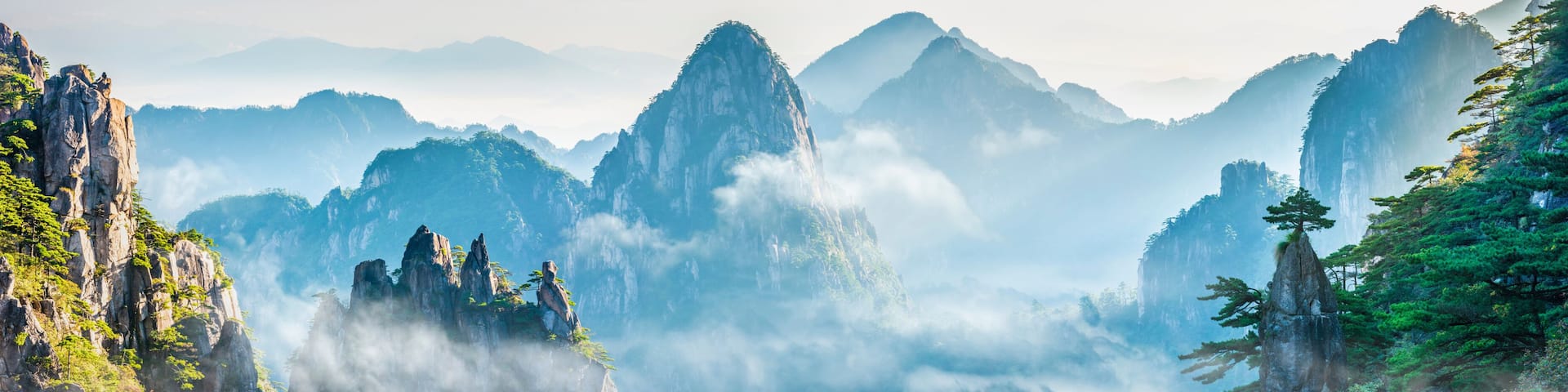 Un paisaje montañoso con imponentes formaciones rocosas y abundante vegetación.