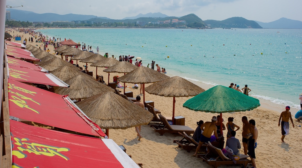 Dadonghai Beach showing a beach and general coastal views as well as a large group of people