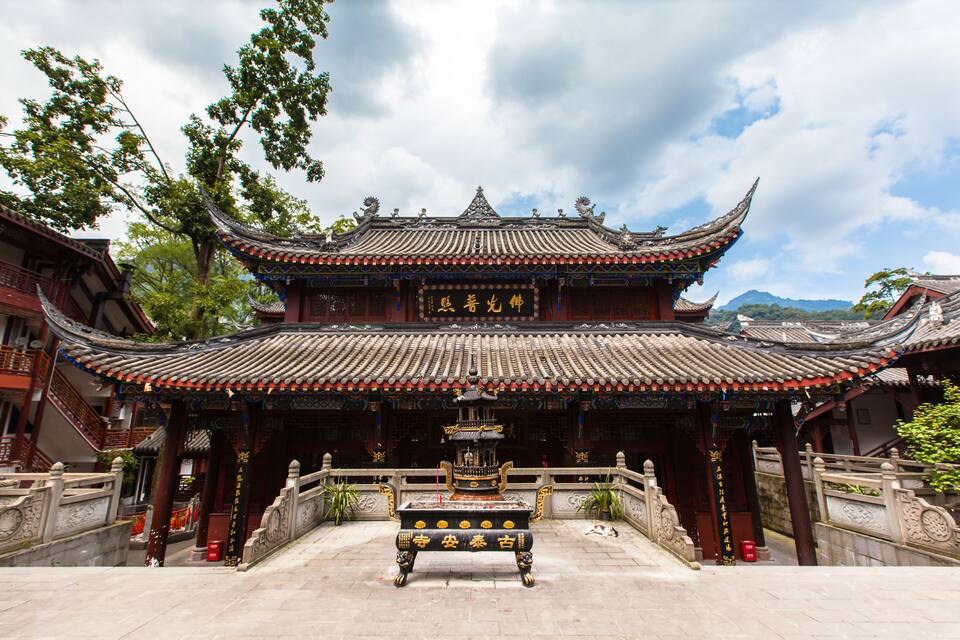 A traditional Chinese temple with ornate architecture, a central altar, and a stone staircase leading up to the entrance.