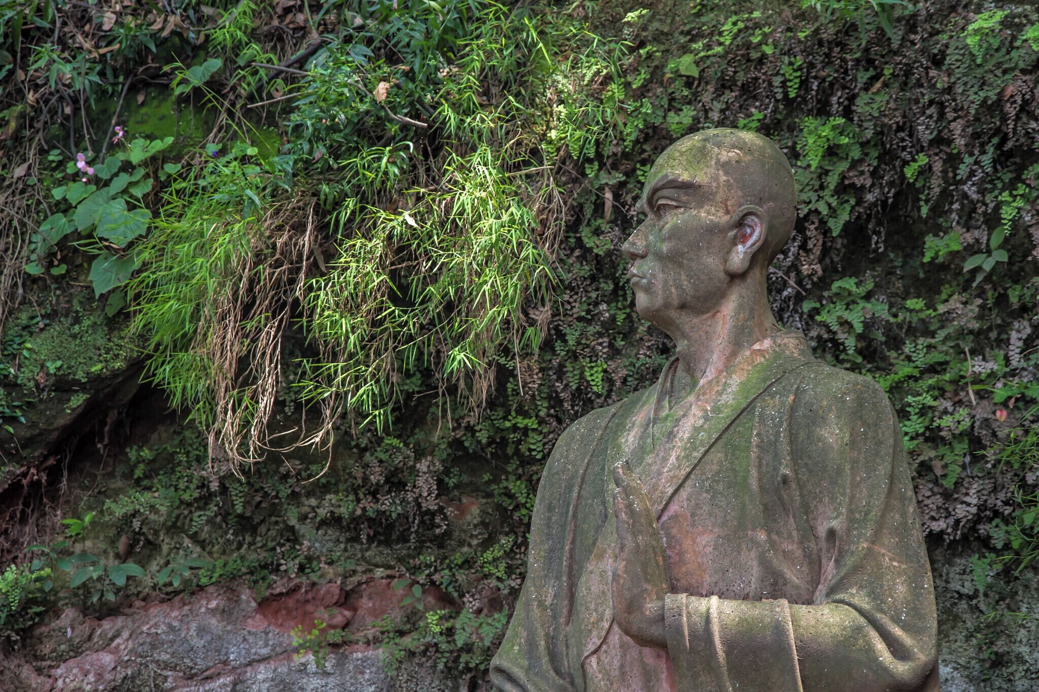The Leshan Giant Buddha statue is said to have been built to calm the turbulent waters that plagued passing boats and killed many people each year. So, in the Tang Dynasty, a monk named Hai Tong, decided to carve a giant statue beside the river, hoping it would appease the river gods and save more local people’s lives. With this belief, the Hai Tong Monk begged for 20 years to acquire enough funds to begin his work.  According to legend, when some local government officials wanted to get large amounts of money from Hai Tong, he said they could have his eyeball but not the money raised for the Buddha statue. When government funding for the project was threatened, the monk is said to have gouged out his own eyes to show his sincerity and devotion to the cause. The officials were scared away, and Hai Tong saved the money and started the project in 713 AD. 

The project was half finished when he passed away and two of his disciples were left to continue the work. The project was finally completed 90 years later by the local governor in 803 AD. 

This statue stands next to a cave behind the Giant Buddah where Hai Tong had lived.

#LikeALocal