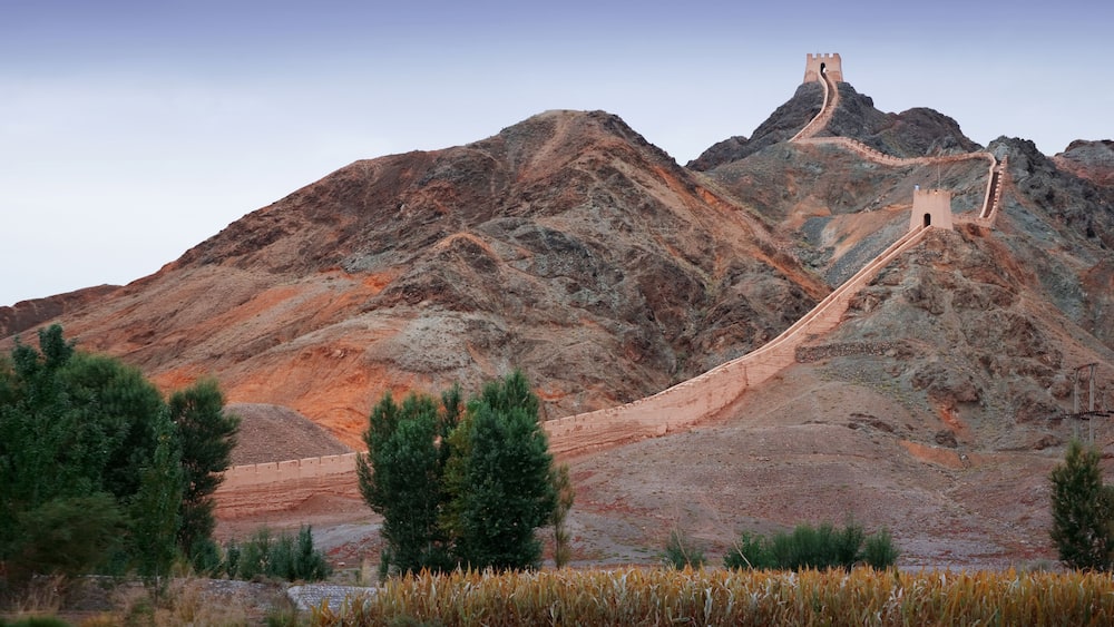 A mountain with a long, winding road leading to a tower on top.