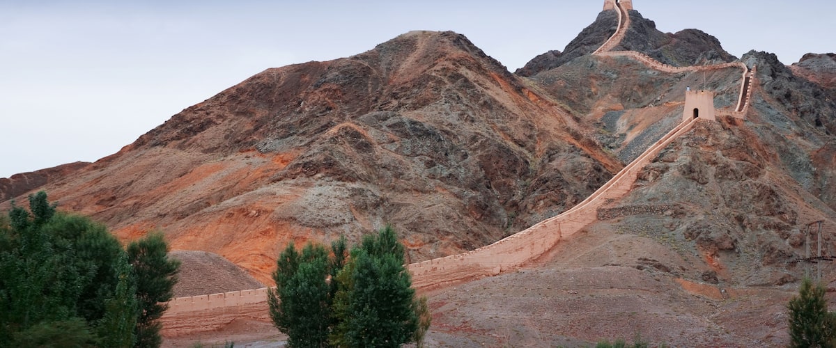 A mountain with a long, winding road leading to a tower on top.