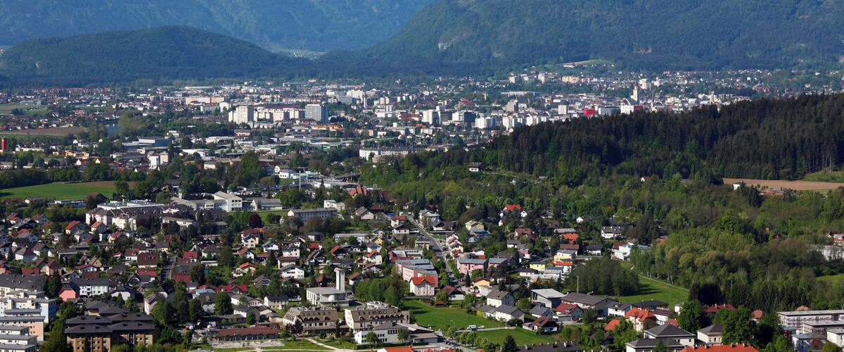 A town nestled between mountains with snow-capped peaks in the background.