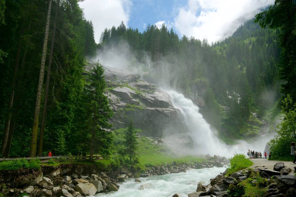 A waterfall cascading down a rocky cliff surrounded by dense forest.