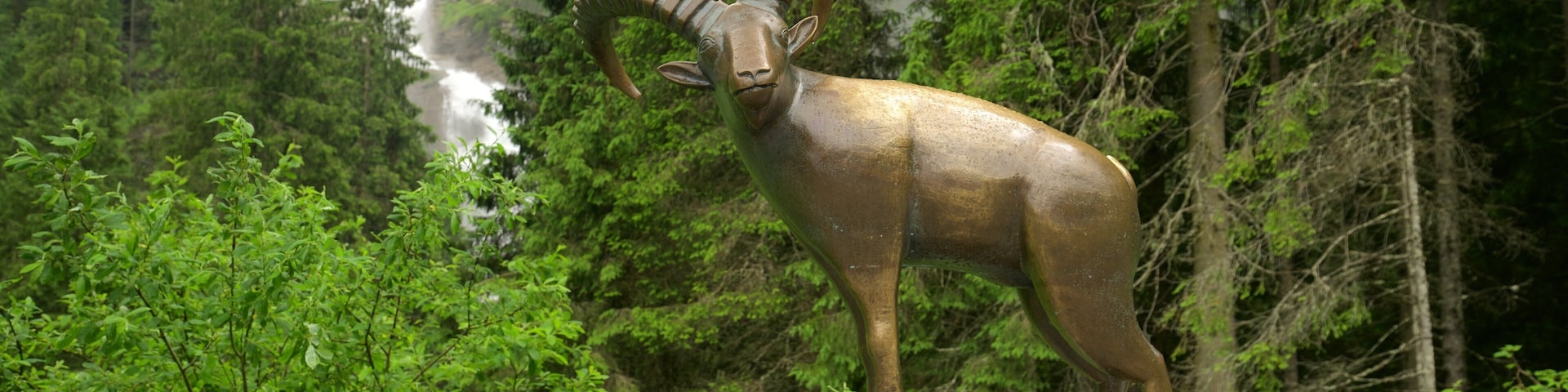 Cataratas Krimmler ofreciendo una catarata, bosques y una estatua o escultura