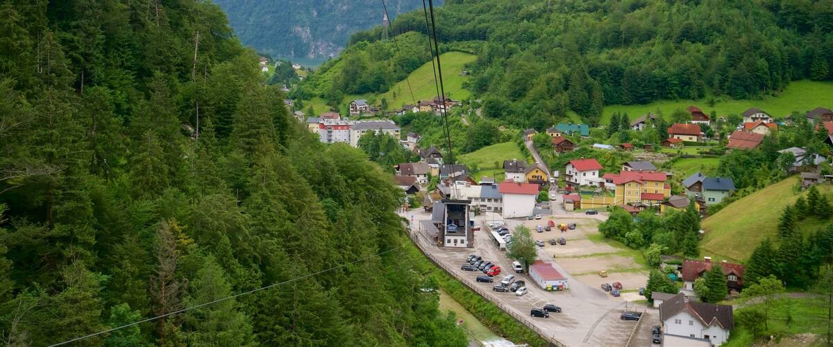 A mountainous village with houses, a road, and a cable car system.