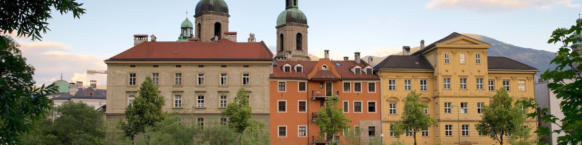 Catedral de Innsbruck mostrando um pôr do sol, elementos de patrimônio e um lago ou charco