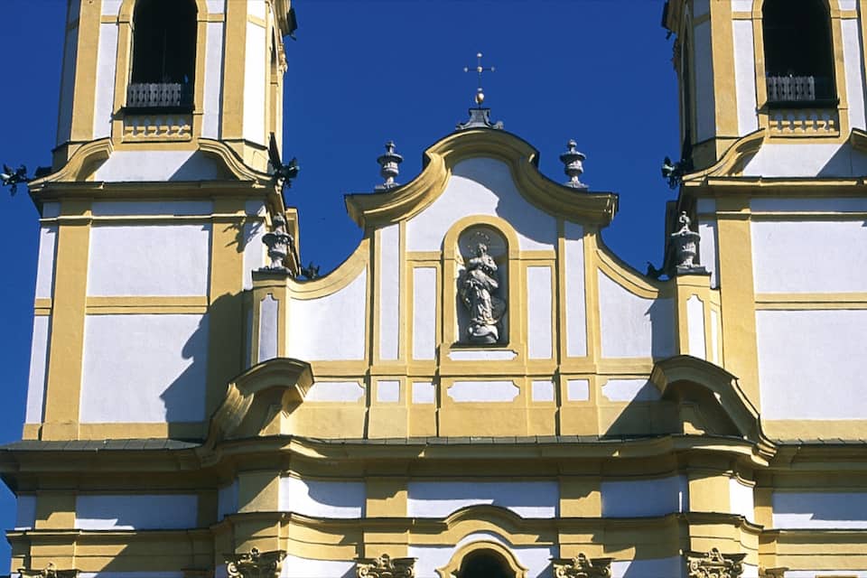 Una iglesia con dos torres de campanas, una cúpula central y estatuas.