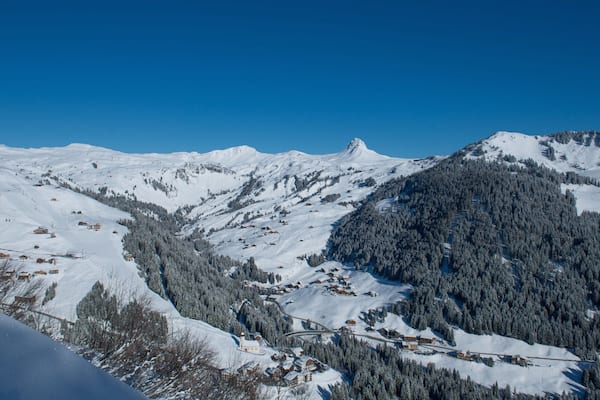 Ein verschneites Gebirge mit wolkenlosem, blauem Himmel.
